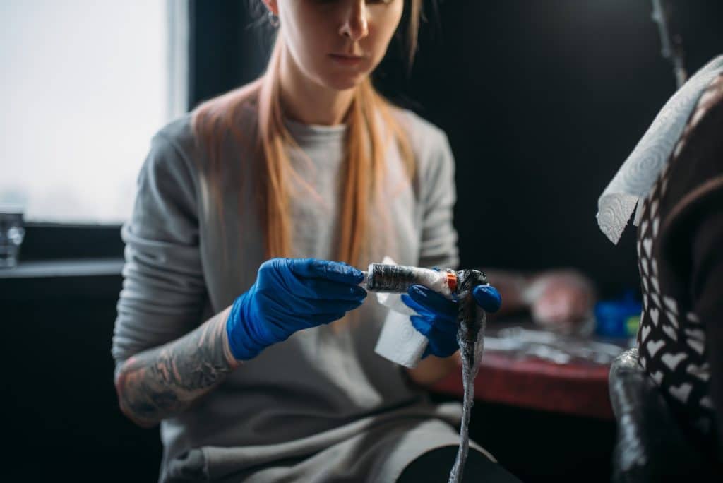 Female tattooist prepares tattoo machine, UV Tattoo Ideas