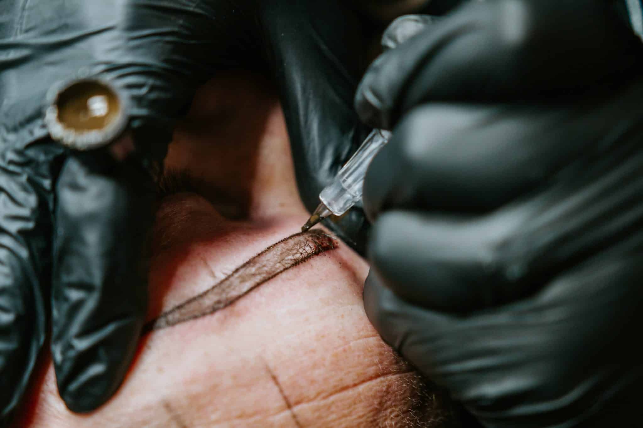 Artist Drawing a Tattoo with pen