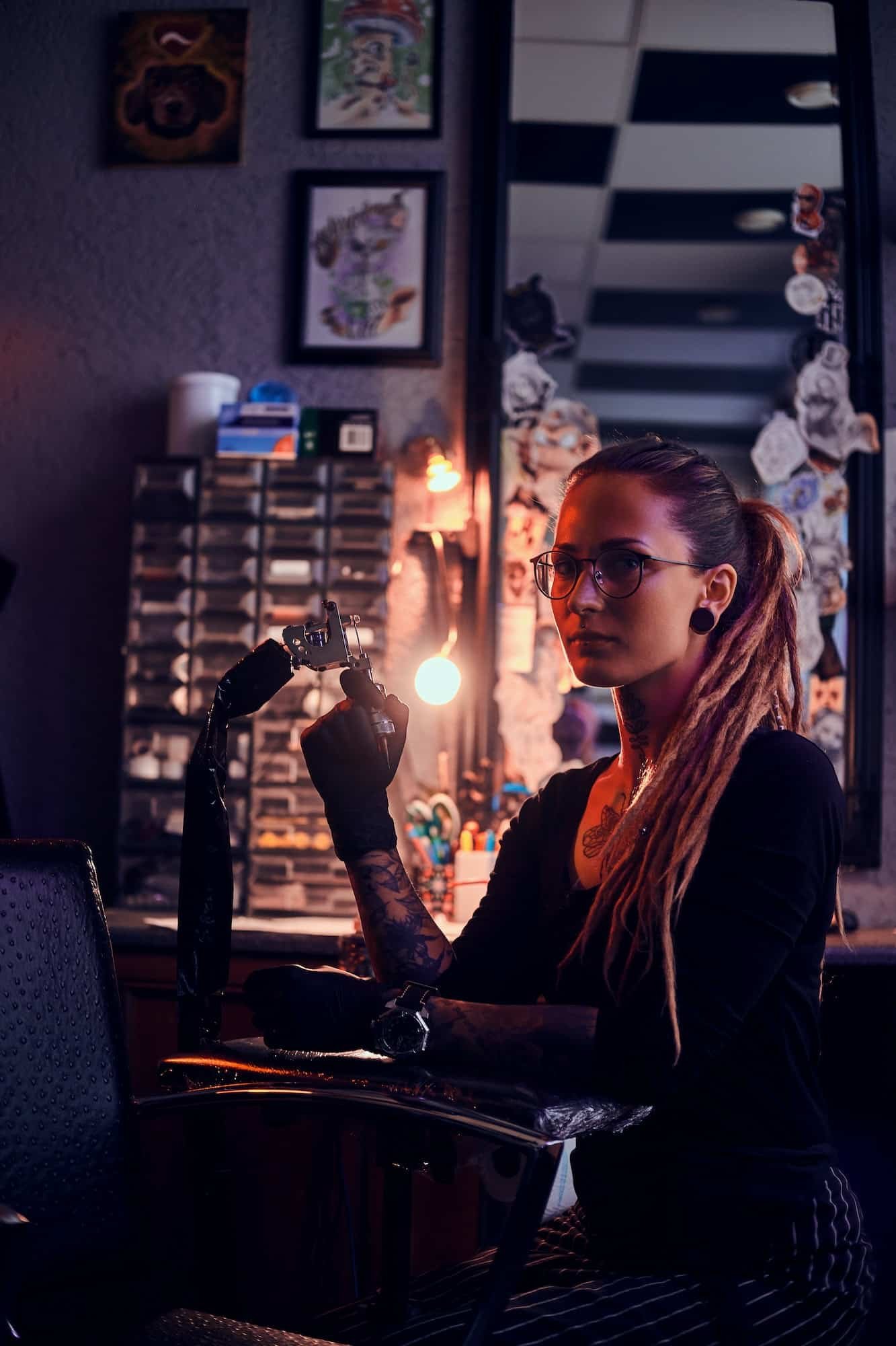 Portrait of pensive tattoo master with tattooing machine