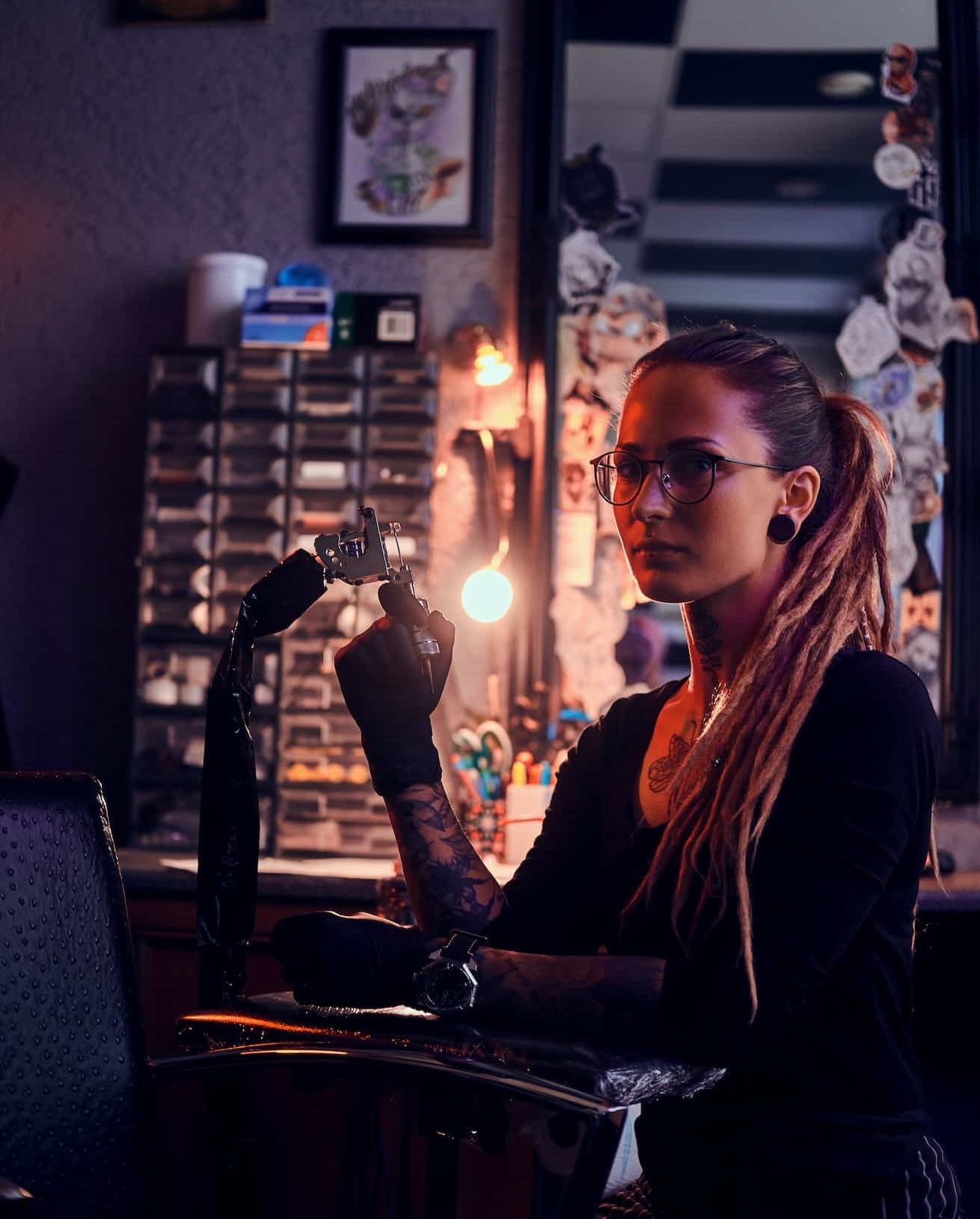 Portrait of pensive tattoo master with tattooing machine