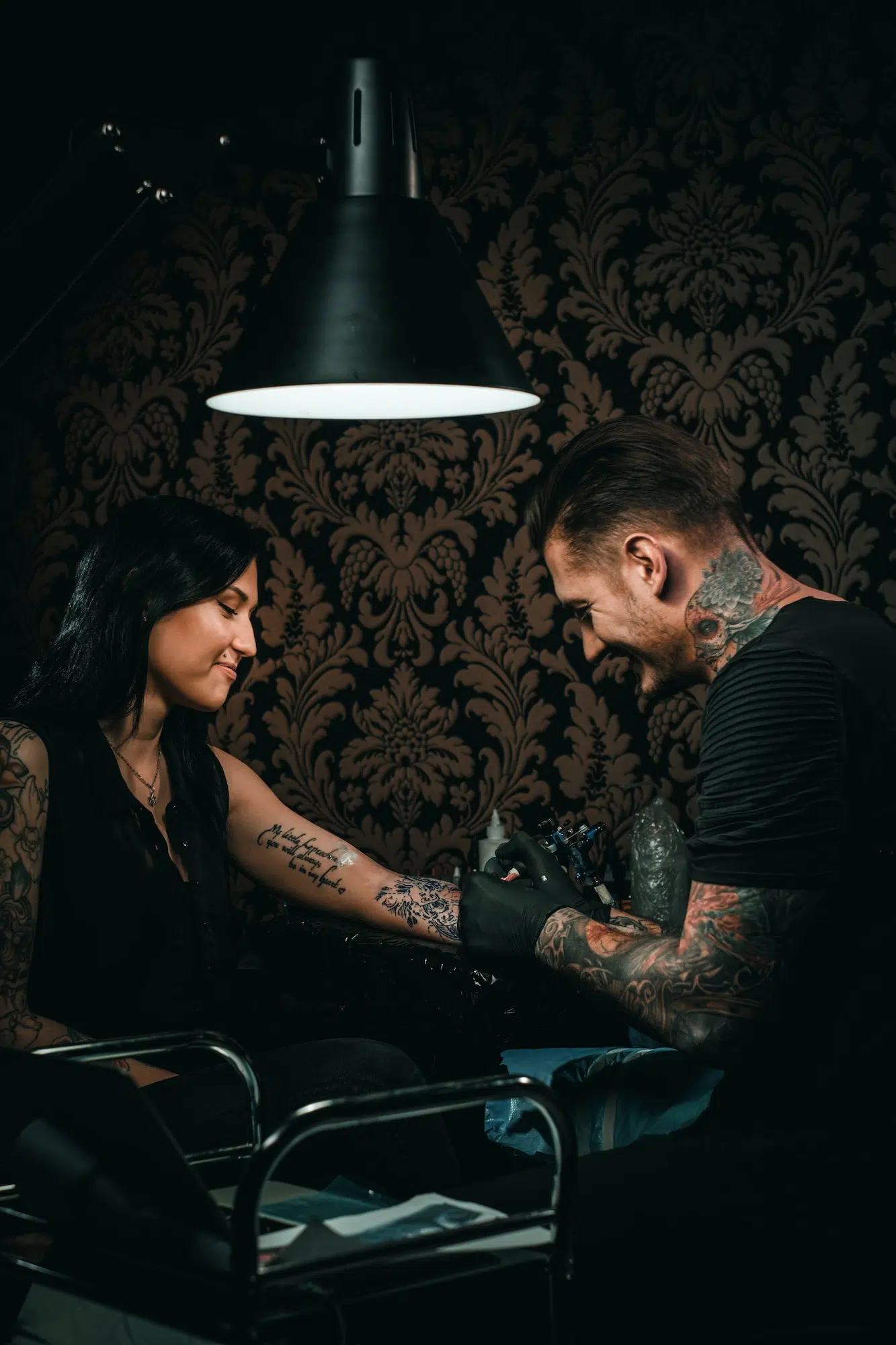 Professional tattoo artist makes a tattoo on a young girl's hand