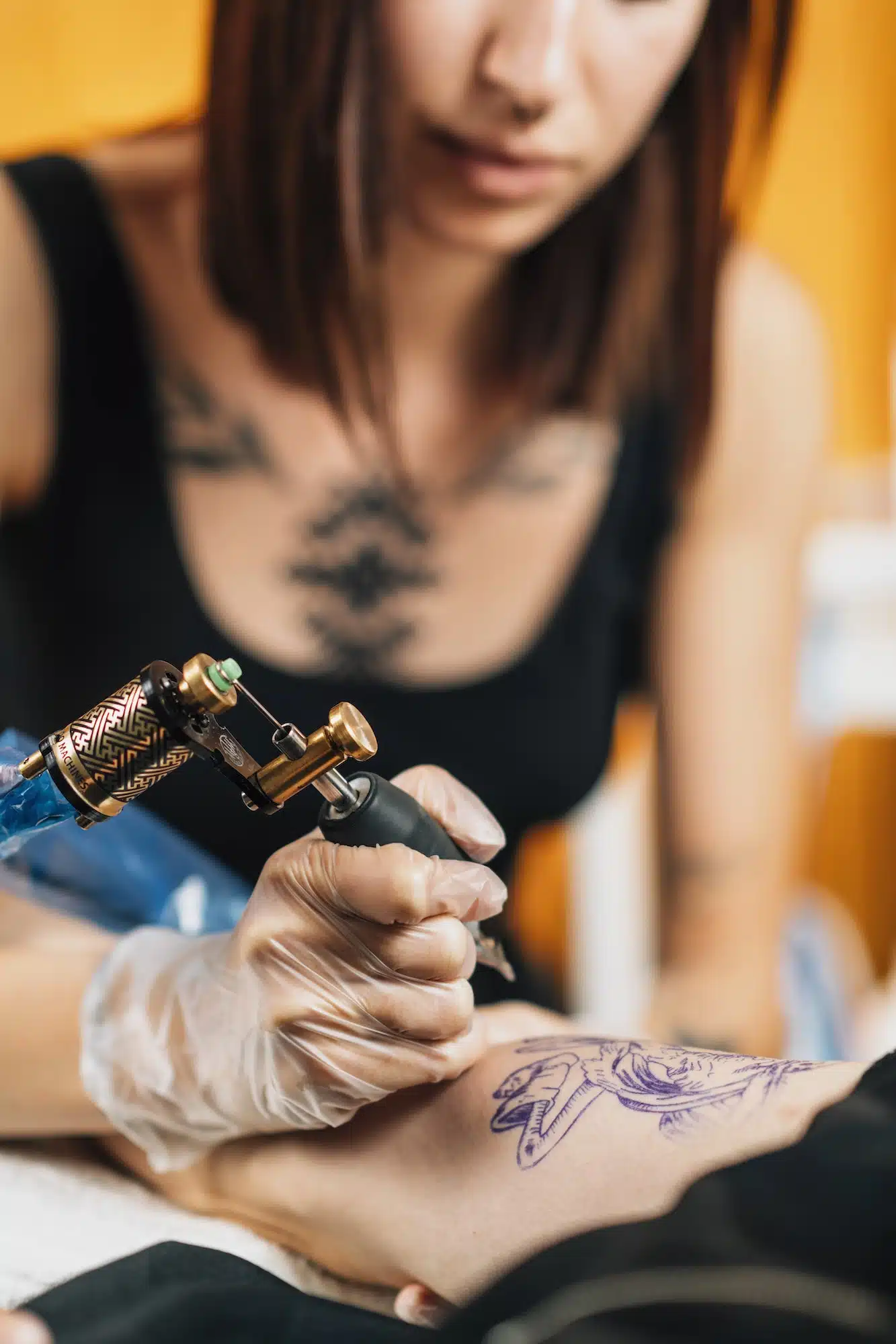 Tattoo Artist Tattooing Man’s Arm in Studio