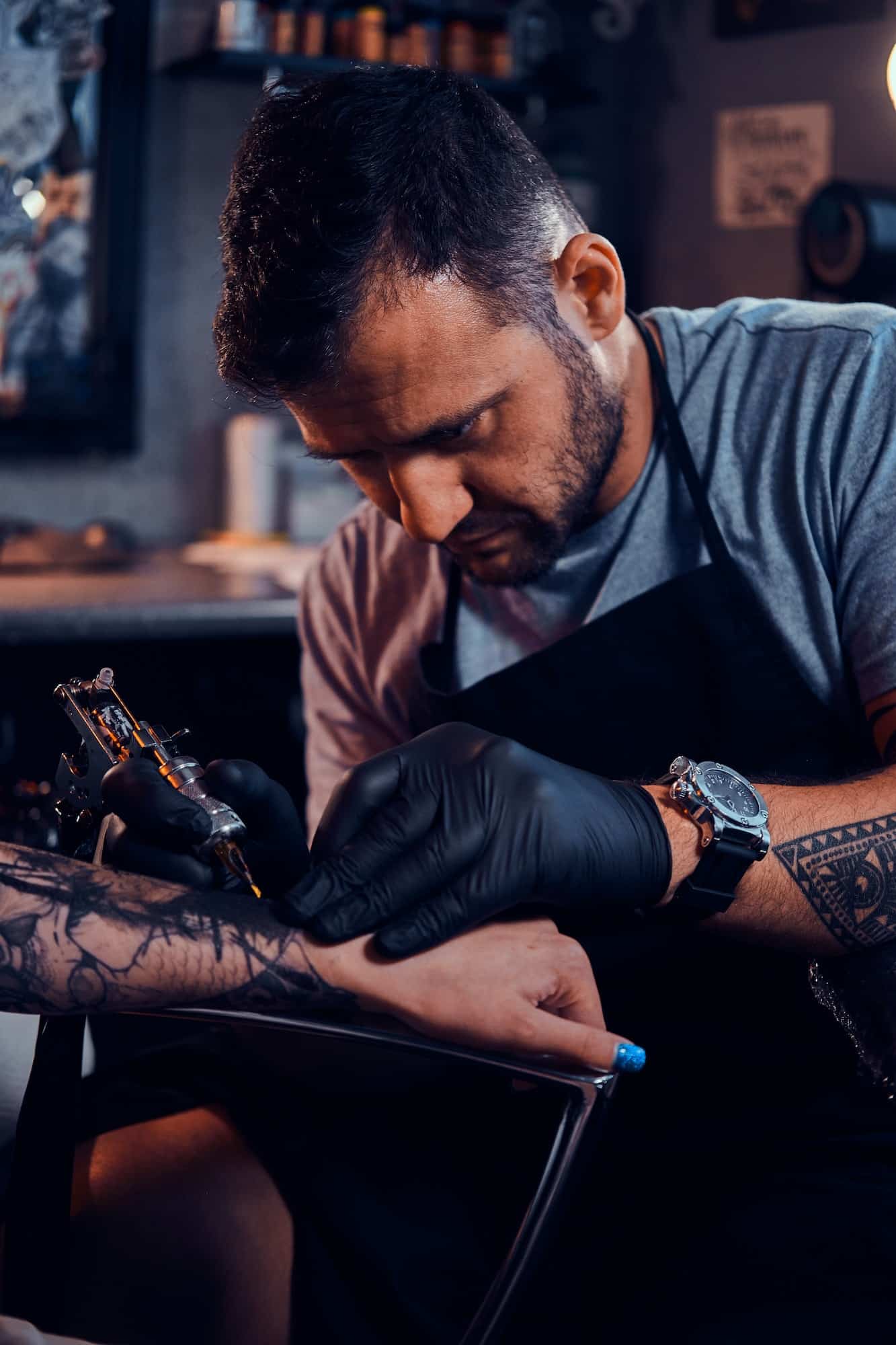 Tattoo master is creating new tattoo for customer