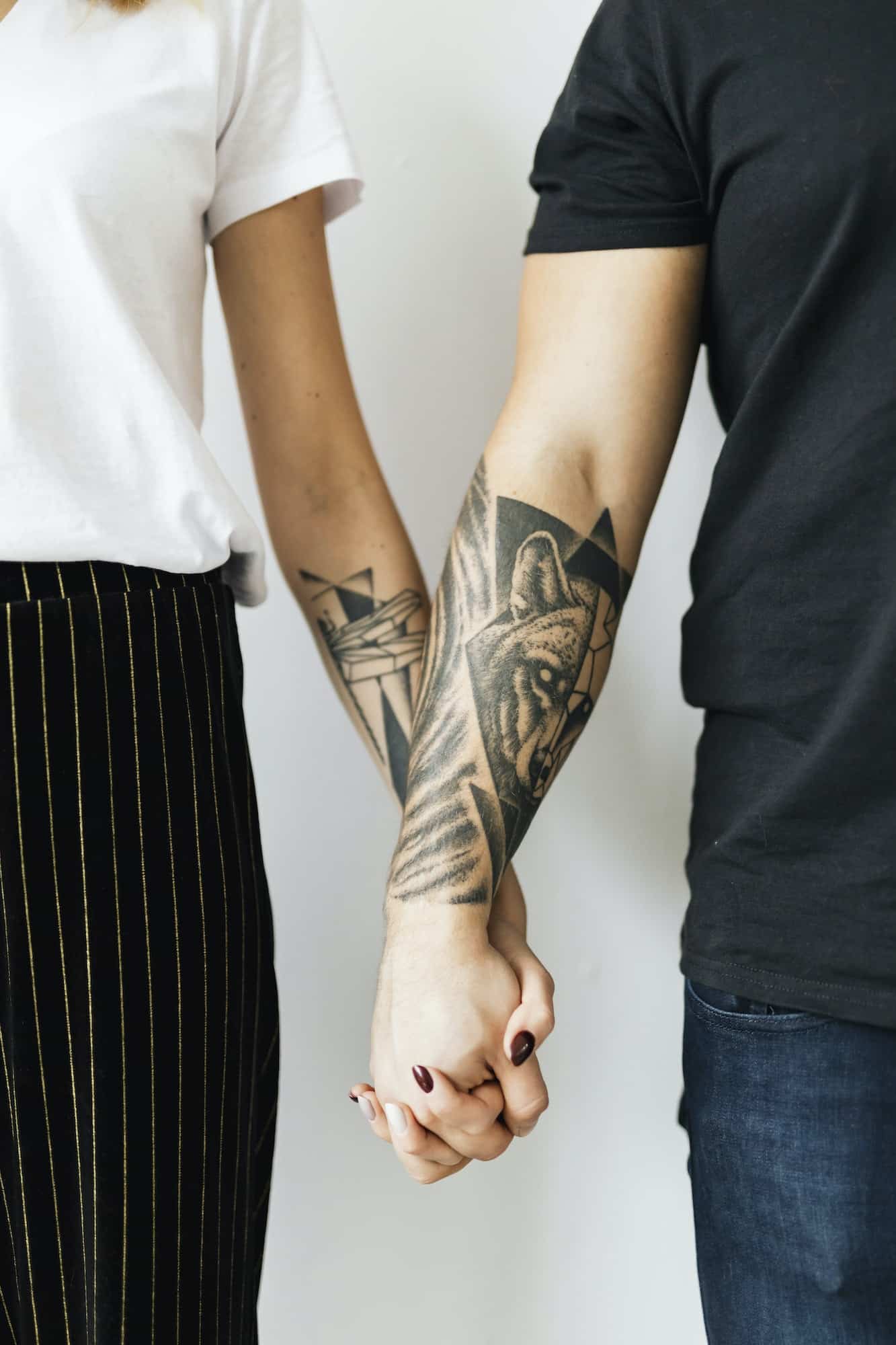 Tattooed hands holding hands