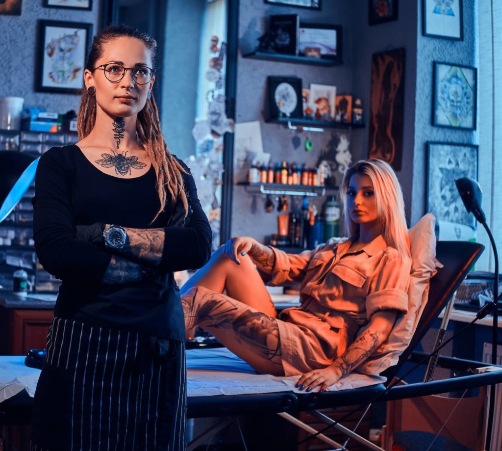 Two beautiful girls at tattoo studio