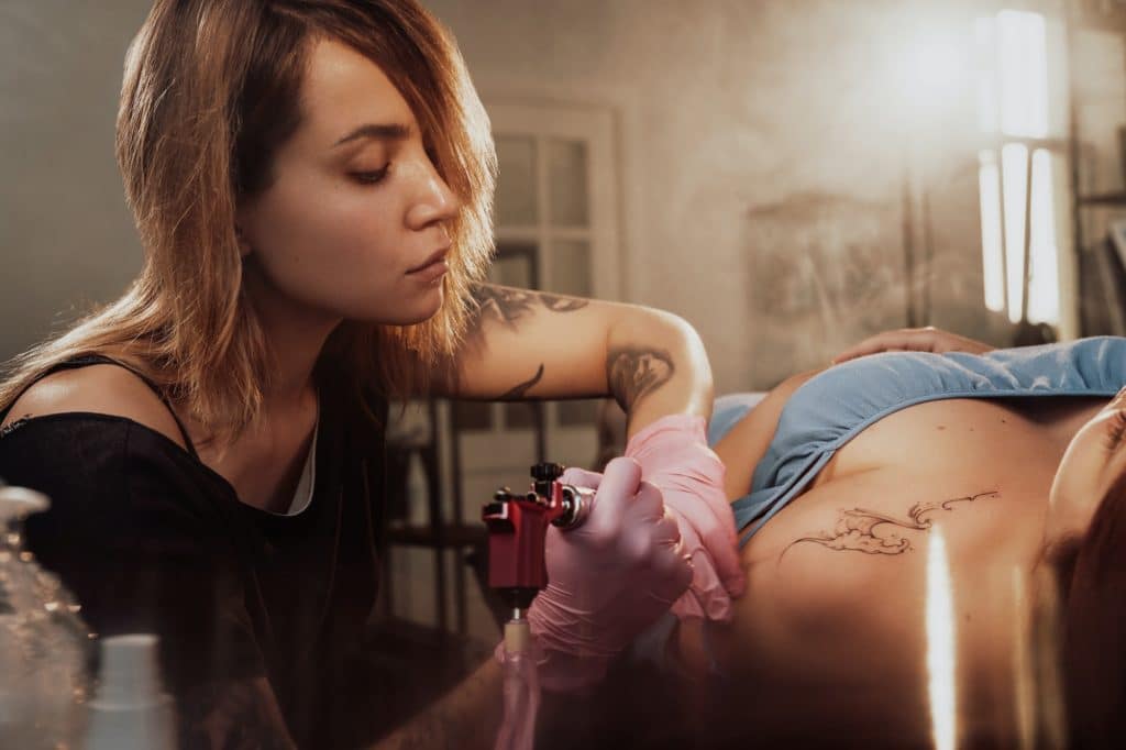 Woman came to female tattoo master in room with sunlight