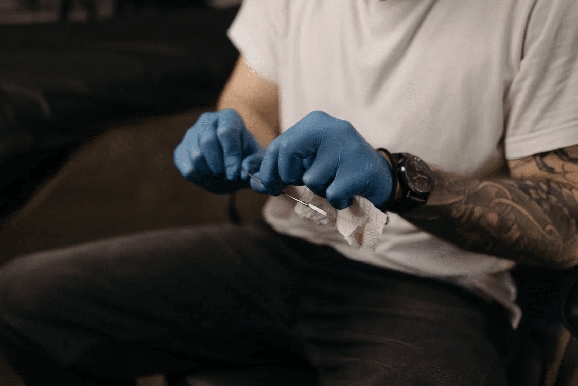 Tattoo Artist cleaning the Needle