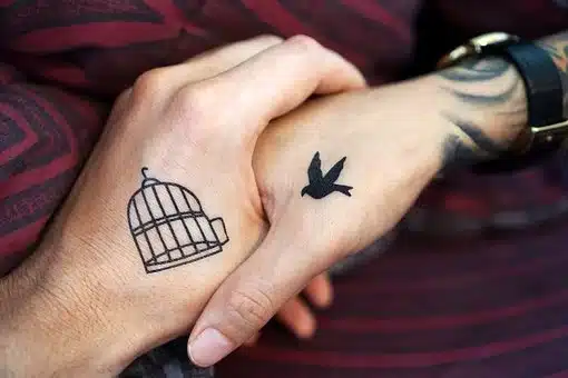 Tattoo on hand of Flying Bird and A Cage