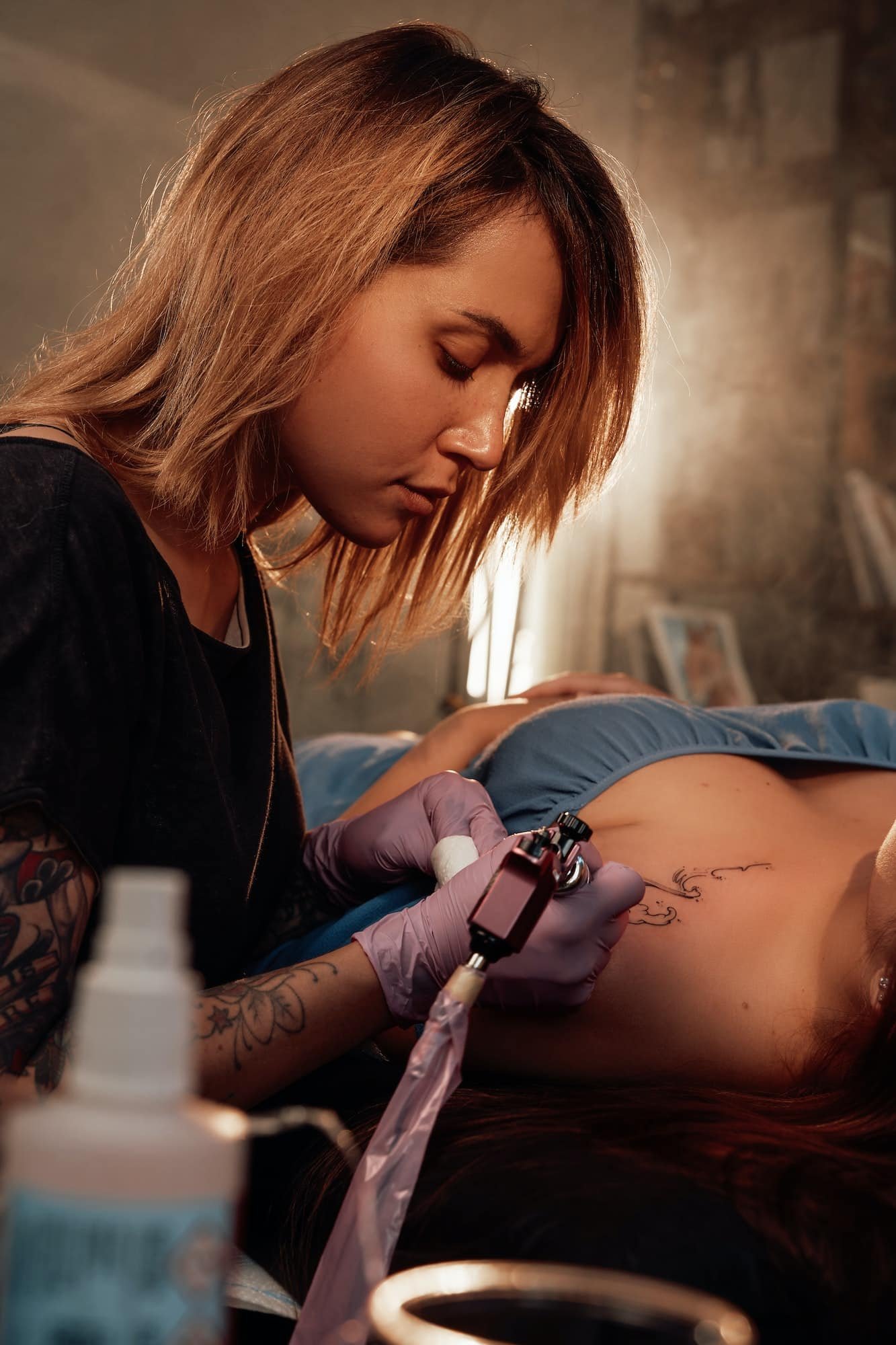 Woman came to female tattoo master in room with sunlight, Mobile Tattoo