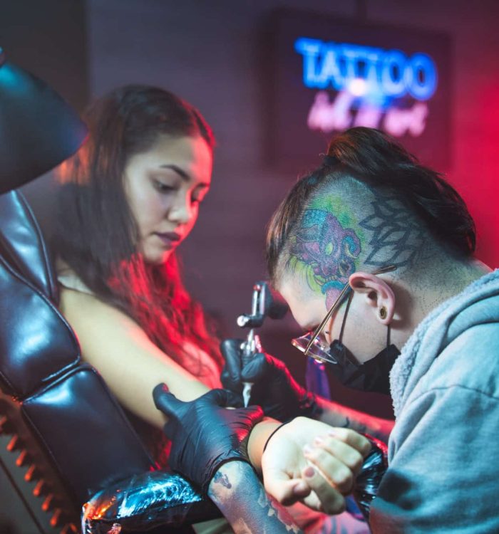 Artist Drawing Tattoo On Client In Parlor, Flower Tattoo