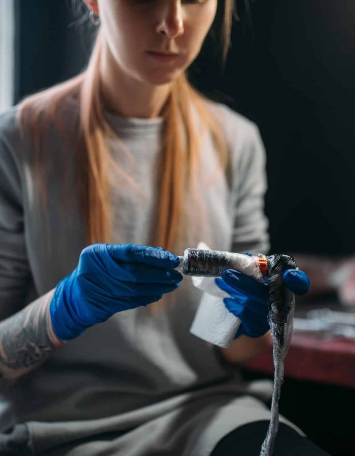 Female tattooist prepares tattoo machine, UV Tattoo Ideas