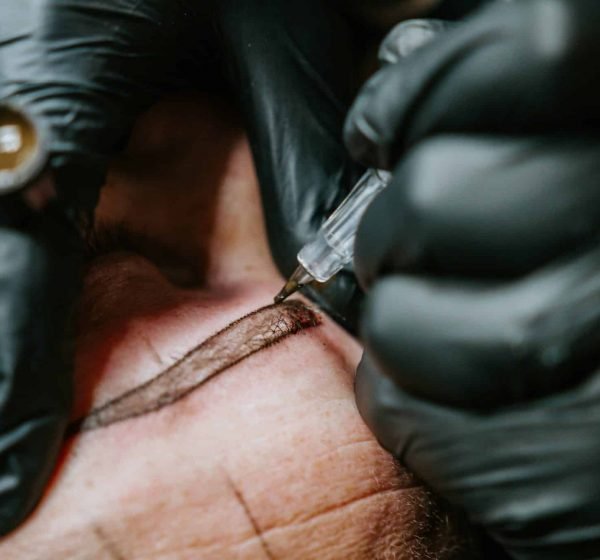 Artist Drawing a Tattoo with pen