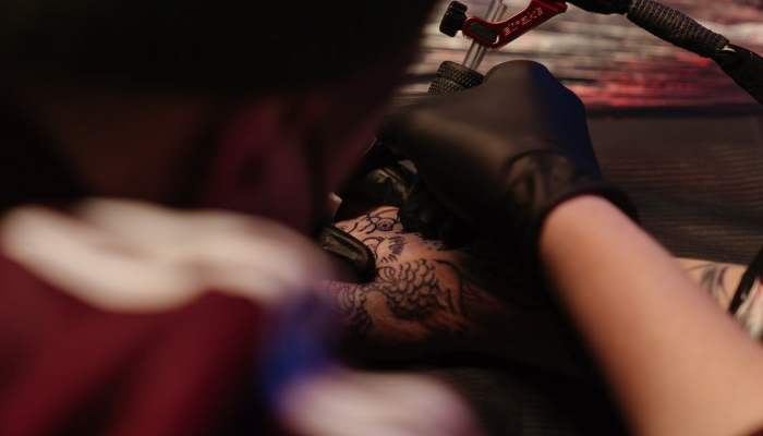 Tattoo Artist making a tattoo on hand