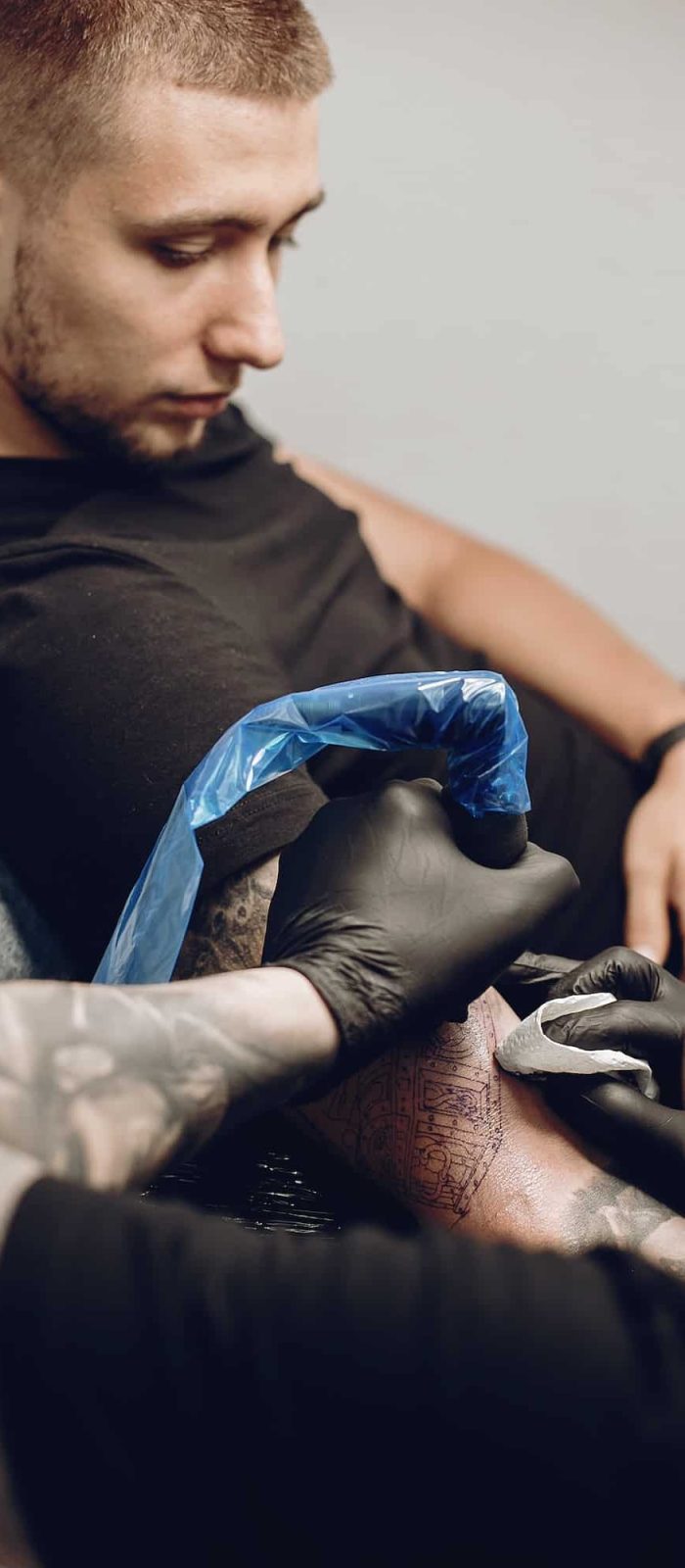Man doing a tattoo in a tattoo salon, arm sleeve tattoos for men, full sleeve tattoo, Tattoo And Piercing