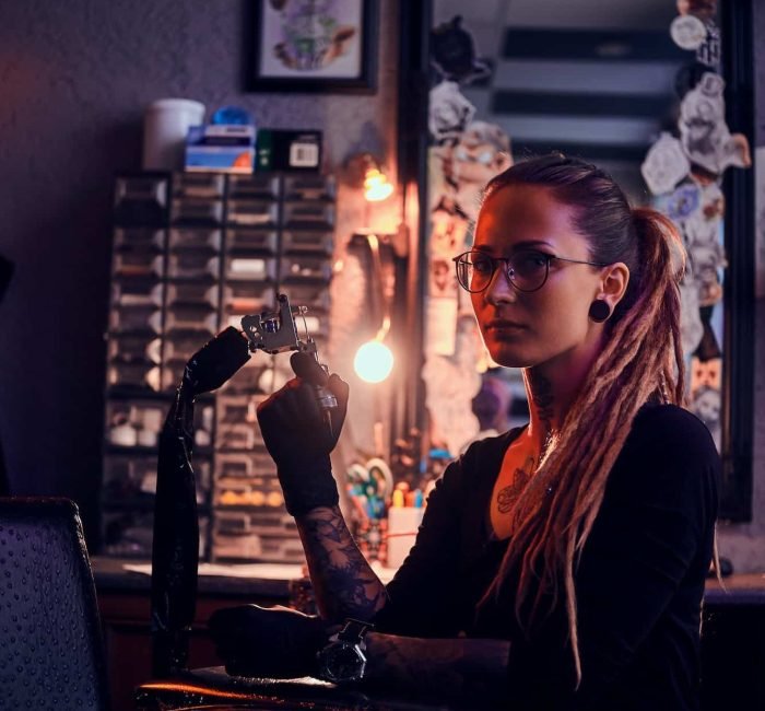 Portrait of pensive tattoo master with tattooing machine