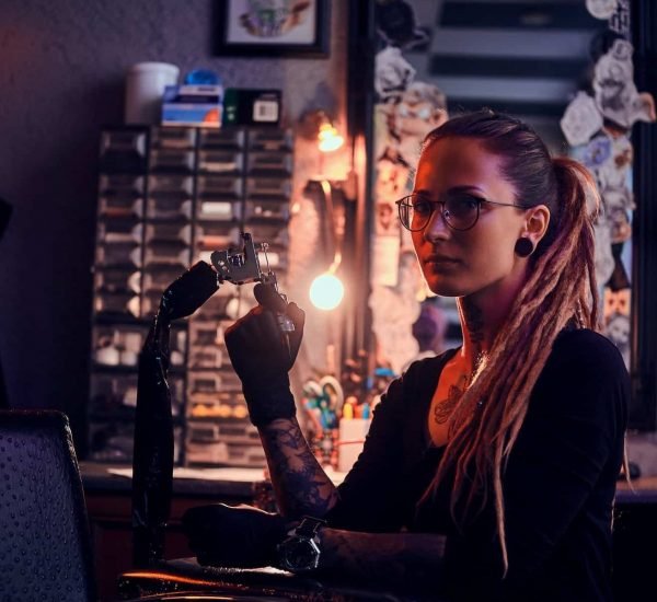 Portrait of pensive tattoo master with tattooing machine