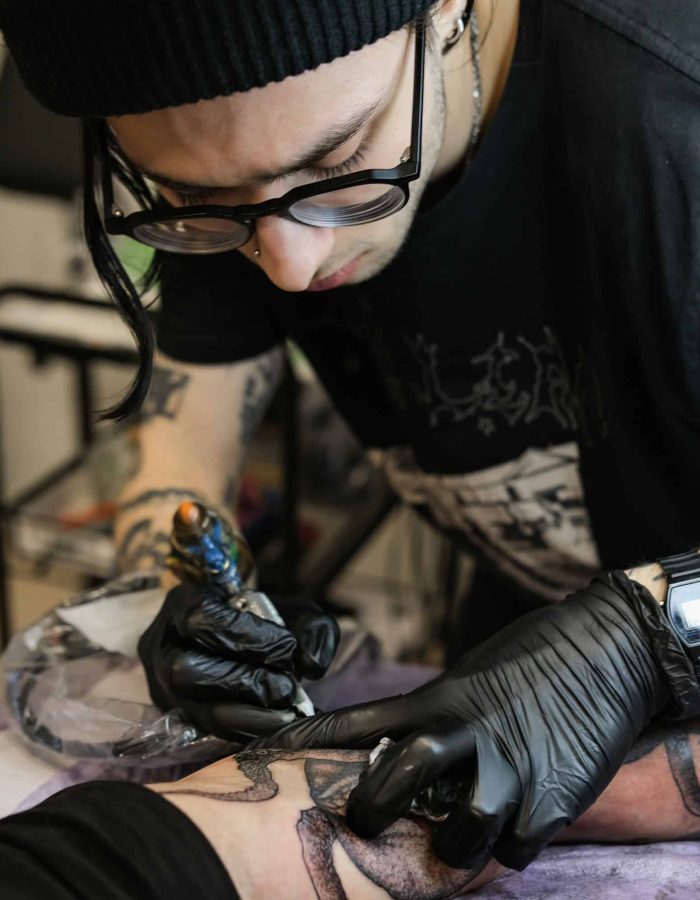 Professional tattoo artist stuffs a tattoo on the man's hand. Small business, Rose Sleeve Tattoo For Women