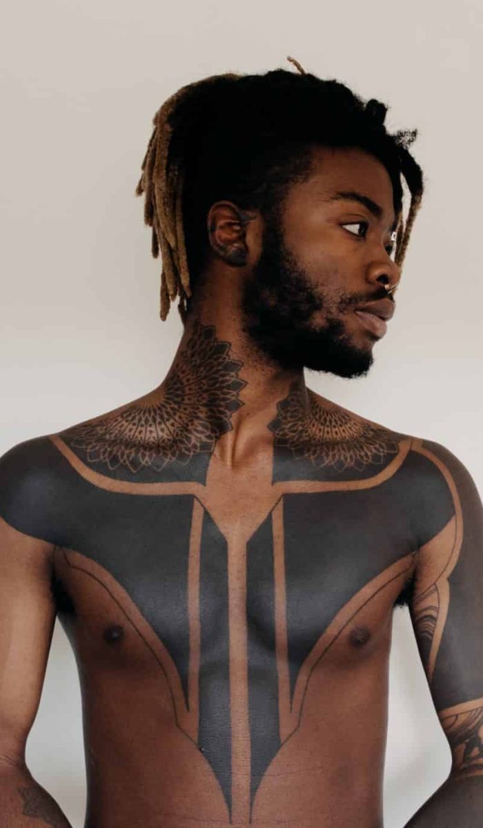 Black tribal tattoo cover up on chest, neck and arm