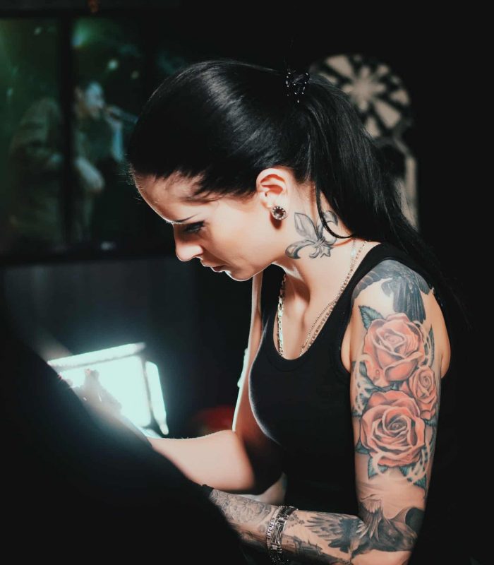 tattoo artist demonstrates the process of getting black tattoo with paint. Concentrated female
