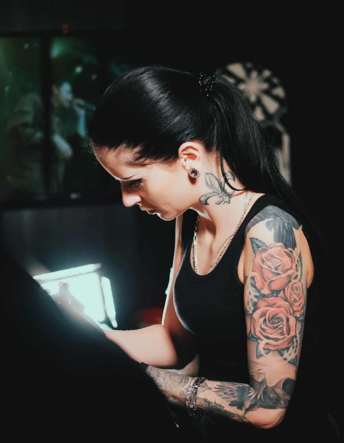 tattoo artist demonstrates the process of getting black tattoo with paint. Concentrated female