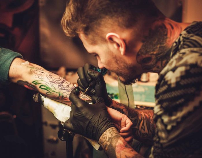 Tattoo artist makes a tattoo on a man's hand, dragon tattoo designs for arms, Small Tattoo For Lost Loved Ones
