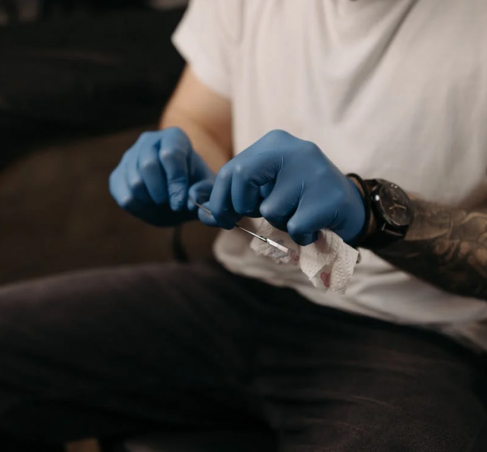 Tattoo Artist cleaning the Needle